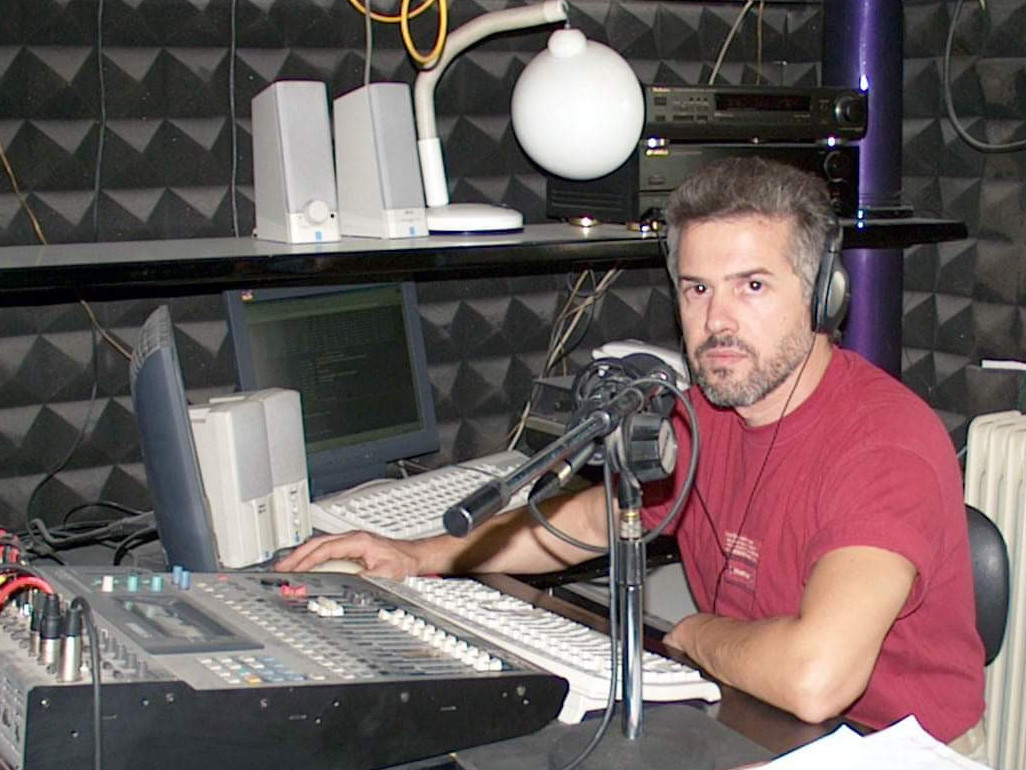 Στην φωτογραφία Ο Ζαφείρης Χαλκιάς κάθεται μπροστά στην κονσόλα ράδιο Μύθος 93,4